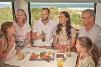 Familie beim Essen in einem Maui Camper