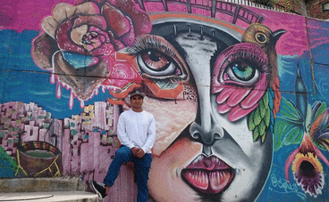 Graffitikünstler Chota in Medellin vor einem beeindruckenden Graffiti